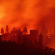 Flames from the Camp fire burn near a home atop a ridge near Big Bend, California.
